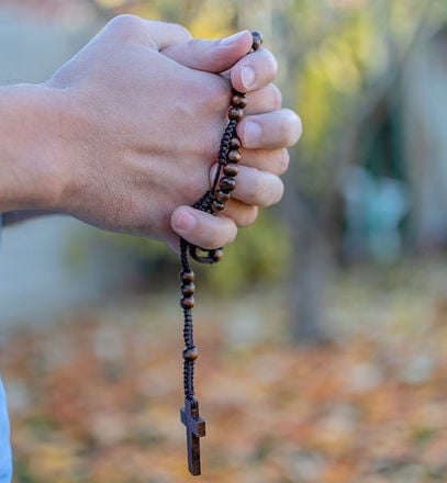 Photo of hands holding a rosary